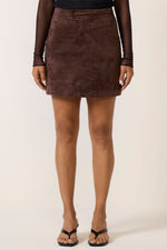 Z SUPPLY Perri Suede Mini Skirt in dark chocolate brown, front view on model styled with black mesh top and sandals