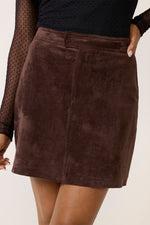 Z SUPPLY Perri Suede Mini Skirt in dark chocolate brown, close-up front view on model styled with black mesh top