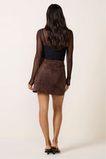 Z SUPPLY Perri Suede Mini Skirt in Dark Chocolate, back view on model wearing black mesh long-sleeve top and black heeled mules