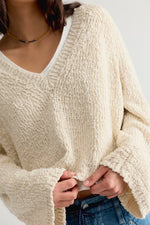 Free People Heartland Pullover in Tofu, close-up detail of cream chunky knit V-neck sweater worn by model over white tee