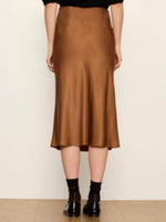 Sanctuary Everyday Midi Skirt in Cocoa Powder, back view on model, satin bias-cut silhouette with flared hem, worn with black loafers