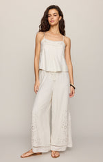 Z SUPPLY Lille Embroidered Woven Tank in white on model, featuring spaghetti straps and floral embroidery, paired with matching wide-leg pants
