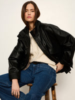 Sanctuary Alana Jacket in black faux leather, oversized bomber style, worn by model over cream sweater and blue jeans, front view