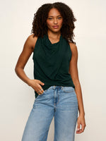 Sanctuary Nora Draped Tank in forest green worn by model, featuring cowl neckline, sleeveless silhouette, and draped front detail