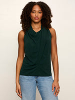 Sanctuary Nora Draped Tank in forest green with cowl neckline and twist front detail, worn by model with blue jeans, front view.