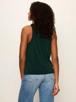 Sanctuary Nora Draped Tank in forest green, back view on model, featuring racerback silhouette, paired with light wash jeans