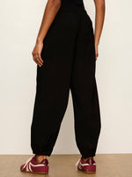Sanctuary Micro Balloon Pant in black, back view on model, featuring elastic waistband, relaxed balloon silhouette, and banded ankles