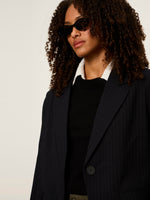 Sanctuary Maci Blazer in navy pinstripe worn by model with curly hair and cat-eye sunglasses, close-up front view