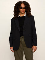 Sanctuary Maci Blazer in navy pinstripe, single-button closure with notched lapels, worn by model over black sweater and olive cargo pants