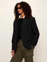 Sanctuary Maci Blazer in navy pinstripe, single-button closure, worn by model with olive cargo pants and black sweater, three-quarter view.
