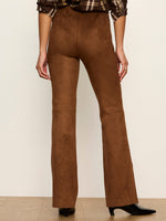 Sanctuary Sashay Legging in Cocoa Powder — back view of brown suede flare-leg leggings on model with plaid top and black heels.