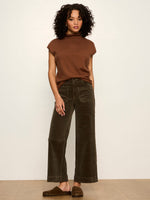 Sanctuary Chelsea Wide Leg corduroy pants in Kalamata olive green, front view on model styled with brown mock-neck top and studded clogs