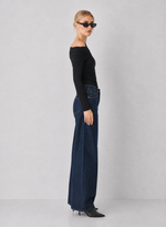 Steve Madden Ryder Knit Top in black, off-shoulder ruched long-sleeve top worn by model with dark wide-leg jeans, side view