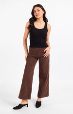 Sadie Ruby Studded Knit Tank in black, worn by model with scoop neckline and stud detailing, paired with wide-leg brown trousers