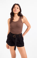 Sadie Ruby Studded Knit Tank in brown with gold stud neckline detail, worn by model with black belted shorts, front view.