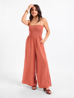 Sadie and Sage Sugarloaf Stripe Jumpsuit in mahogany with smocked bodice, wide-leg pants, and spaghetti straps, front view on model.