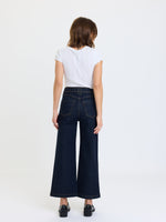 Daze Denim Valley Girl High Rise Patch Pocket Wide Ankle jeans in Rinse, back view on model with white crop tee and black loafers
