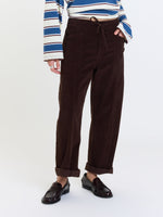 Daze Denim Villa Pant in Chocolate brown corduroy, barrel-leg fit with drawstring waist, patch pockets, and cuffed hem, styled with loafers.