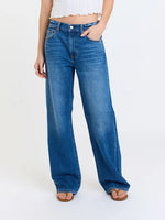 Daze Denim 2K Mid Rise Relaxed Baggy jeans in medium blue wash, front view on model with wide-leg silhouette and sandals