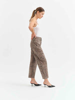 Daze Denim Westward Barrel Leg jeans in Cool Cool Cat leopard print worn by model with white tank top and black heels