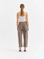 Daze Denim Westward Barrel Leg jeans in Cool Cool Cat leopard print, back view on model with white tank top and black heels