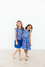 Two girls wearing Mila & Rose Tank Twirl Dresses in blue floral Dreaming Daisies print with coordinating blue skirt
