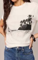 Z SUPPLY La Playa Boyfriend Tee in Sea Salt — cream tee with black beach and palm tree graphic, worn with blue jeans, front view.