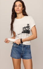 Z SUPPLY La Playa Boyfriend Tee in Sea Salt, white tee with black tropical beach palm tree graphic, worn by model with denim shorts, front view.