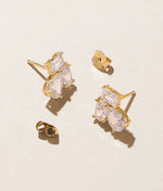 Sahira Pamela Stud Gold earrings flat lay showing crystal baguette and teardrop CZ cluster studs with gold butterfly backs