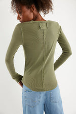 Free People Jamie Henley in Capulet Olive, back view on model, showing center seam detail and patch label on long-sleeve top.