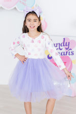 Mila Never Miss A Beat L/S Tutu Dress in white with colorful hearts and lavender tulle skirt, worn by young girl with matching bow