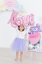 Mila Never Miss A Beat L/S Tutu Dress in white with heart print and lavender tulle skirt, worn by young girl holding 'love' balloon