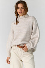 Free People Beaumont Tunic in Feather Grey Melange, oversized mock-neck knit sweater with balloon sleeves, worn by model with cream jeans.