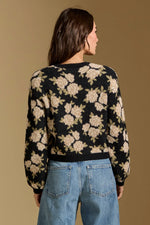 Saltwater Luxe Calian Sweater in black with cream floral pattern, back view on model wearing blue jeans