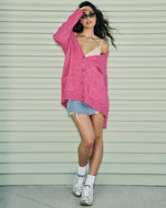 Steve Madden Finley Sweater in hot pink worn by model with denim mini skirt, sneakers, and small sunglasses, front view