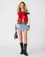 Steve Madden Rooney Jacket in red and cream varsity style with black letter patches, worn by model with denim mini skirt and black boots