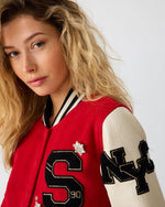 Steve Madden Rooney Jacket in red with cream leather sleeves, black varsity patches spelling 'S' and 'NY', crystal star pins, worn by model