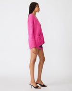 Steve Madden Finley Sweater in hot pink, oversized V-neck cardigan with patch pockets and button front, side view on model