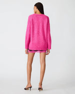 Steve Madden Finley Sweater in hot pink, back view on model with lace mini skirt and black heels