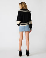 Steve Madden Dara Sweater in black with cream stripes, wide collar, back view on model styled with denim mini skirt and black boots.