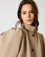 Steve Madden SA04169 TANN trench coat in tan, worn by model, featuring puff shoulders, high collar, and dark buttons