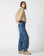 Steve Madden SA04169 TANN sneakers in tan, worn by model with wide-leg jeans, side view showing wedge sole and straps.