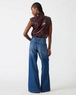 Steve Madden SC01142 faux leather vest in Deep Fig, back view on model styled with wide-leg jeans, sleeveless moto design.