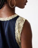 Steve Madden SC09035 sleeveless top in Midnight navy with cream floral lace trim at neckline and armhole, close-up back view on model.