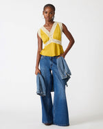 Steve Madden SC09035 satin lace-trim camisole top in Oilslick yellow, worn by model with wide-leg jeans and denim jacket.