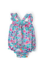 Mila & Rose Ruffle Cross Back Romper in vibrant tropical floral print with pink, purple, teal flowers and leaves on light background