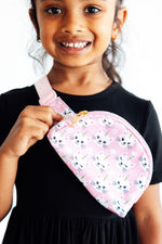 Mila Unicorn Kitties Belt Bag in pink with white cartoon cat faces, held by a smiling young girl in a black dress