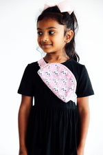 Mila Unicorn Kitties Belt Bag in pink with white cat faces, worn crossbody by a young girl in a black dress.