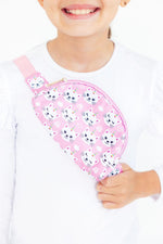 Mila Unicorn Kitties Belt Bag in pink with white cat unicorn print, worn crossbody by a smiling young girl in white top.