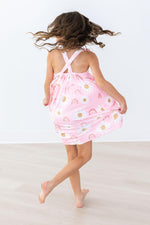 Mila & Rose Ruffle Cross Back Dress in pink with rainbow and dot pattern, back view of child model twirling